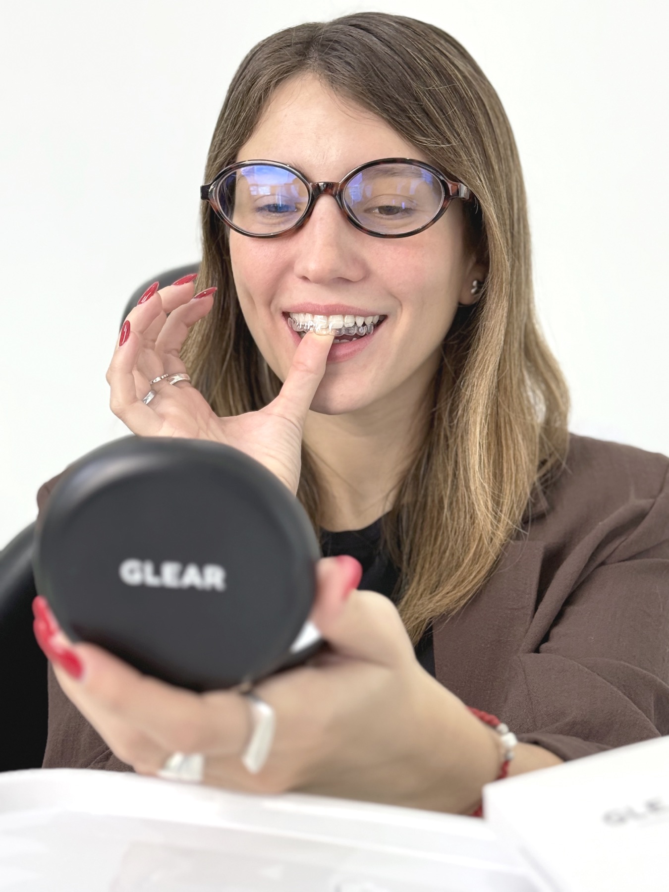 Sonriendo con el espejo GLEAR, colocándose el alineador